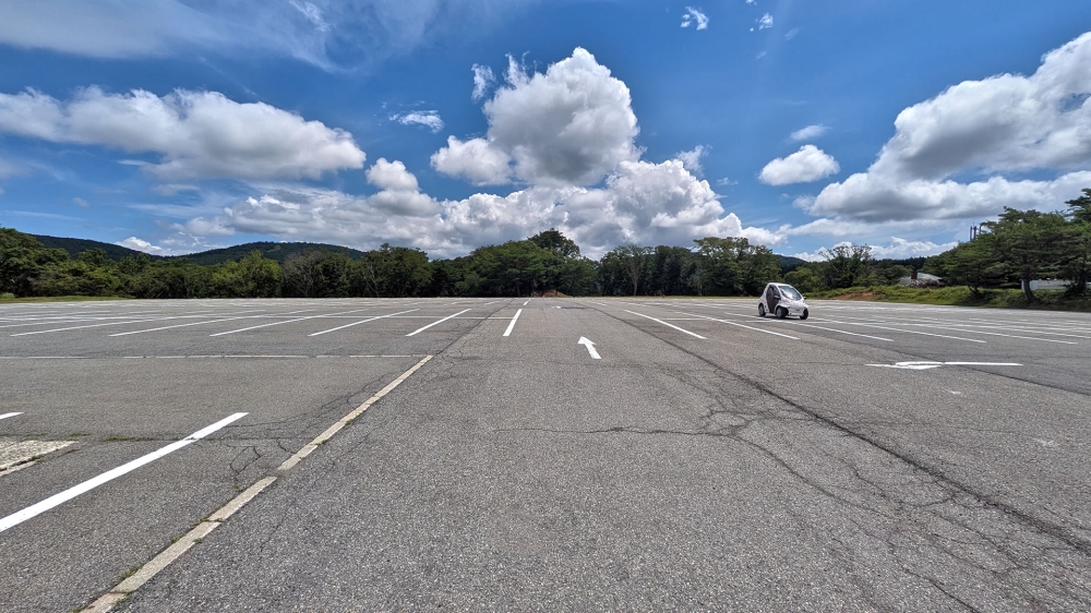 広い駐車場とコムスのカーミン号
