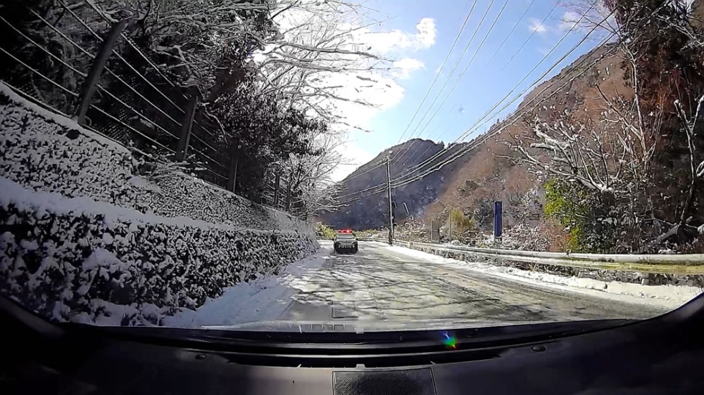 雪の山道とパトカー